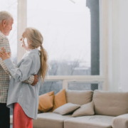 Older couple dancing in the living room of a senior living community