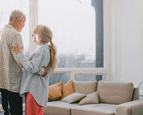 Older couple dancing in the living room of a senior living community